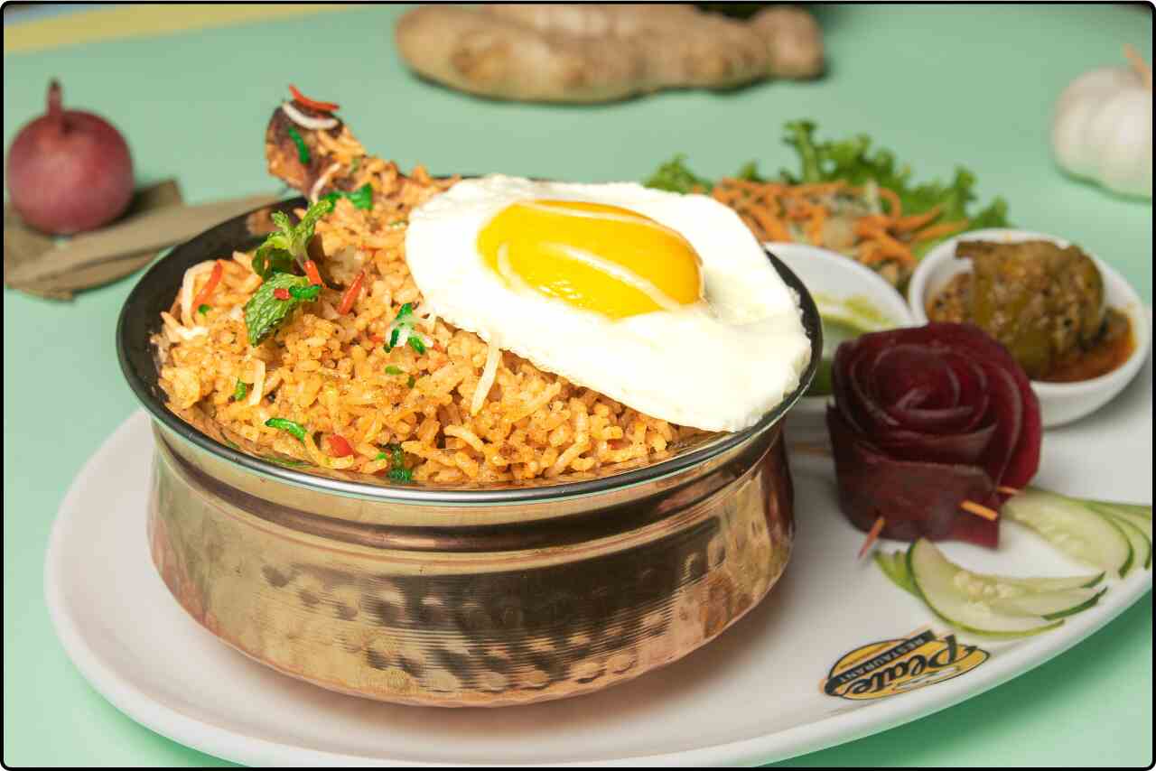 Delicious chicken biryani served with fragrant basmati rice , egg and aromatic spices